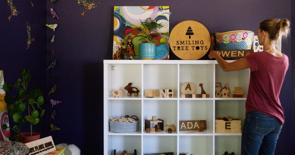 Kathleen Batalden Smith Arranging Toy Display Home Office Smiling Tree Toys - Kathleen Batalden Smith