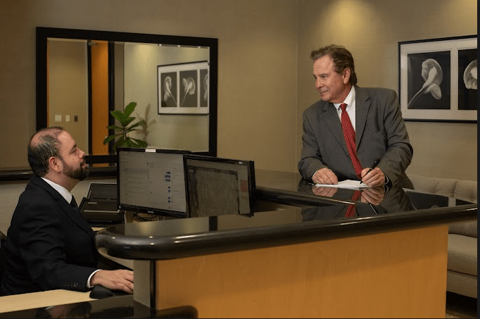 Jeffrey chatting with his employee at a desk in the front office.
Credit: Nadrich Accident Injury Lawyers